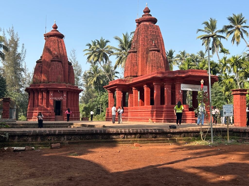 traditional red temple in konkan maharashtra surrounded by coconut trees