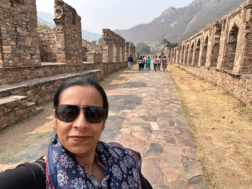 The silent bazaar ruins of Bhangarh Fort stretch toward the hills in the distance.