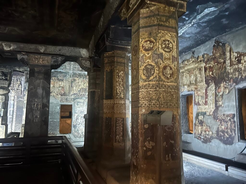 Ancient Buddhist murals and painted pillars inside Ajanta Caves in Maharashtra, India.